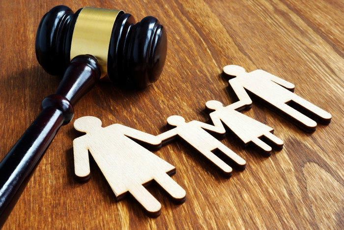 Gavel resting beside paper family figures, representing family law matters